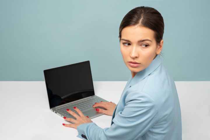 woman holding laptop computer while facing backward